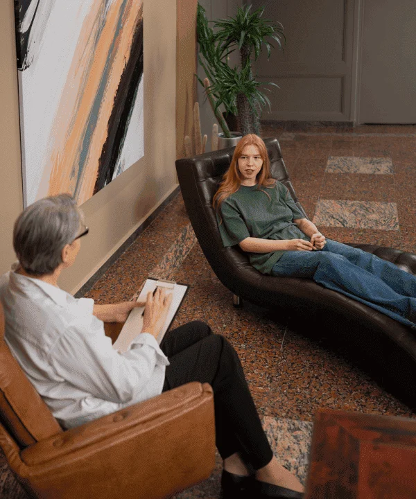 Sesión terapéutica de hipnosis en Hipnosis Group, donde un profesional guía a una paciente en un ambiente cómodo, moderno y confidencial, enfocado en el bienestar emocional y mental.